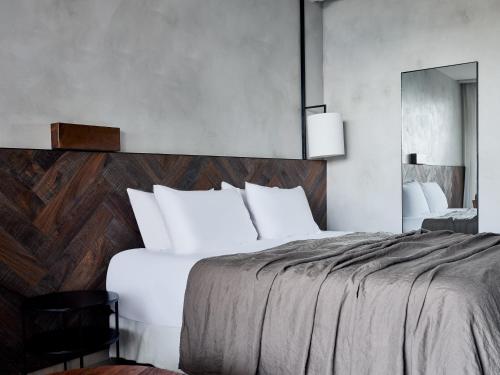a bedroom with a large bed and a mirror at Port Royal Villas and Spa - Adults Only in Kolimbia