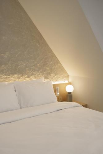 a bedroom with a white bed and a lamp at Hotel Hello Plovdiv - Free Parking and Pet Friendly in Plovdiv