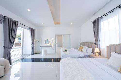 a white living room with two beds and a couch at Leon Pool Villa Pattaya in Ban Huai Yai