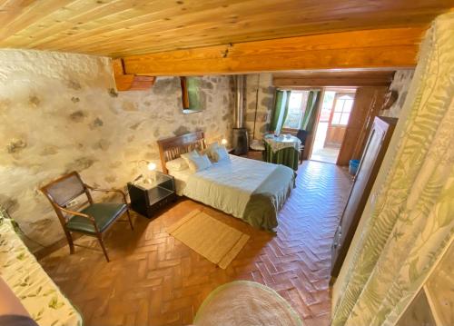 a bedroom with a bed and a chair in a room at Espacio Rural Los Castaños in Cercedilla