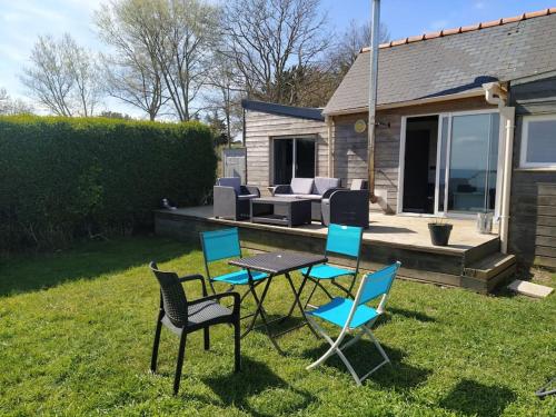 a group of chairs and a table in the grass at Chalet en Bois Unique Séjour Inoubliable Face à la Mer in Plérin