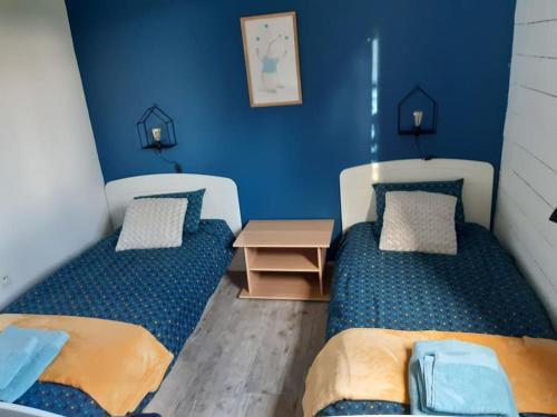 two beds in a room with blue walls at Chalet en Bois Unique Séjour Inoubliable Face à la Mer in Plérin