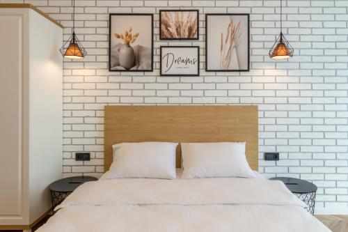 a bedroom with a white brick wall with a bed at Design Apartments with Panoramic View in Kyiv