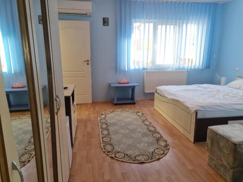 a bedroom with a bed and a door and a rug at Vila turistica UDREA in Eforie Sud