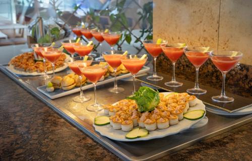 a buffet with plates of food and wine glasses at Hotel Calimera Fido Gardens in Cala d´Or