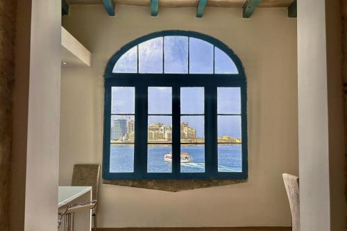 an arched window with a view of the water at Valletta Waterfront Villa with Pool and Jacuzzi in Valletta