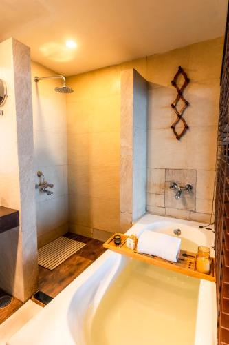 a bathroom with a large tub and a shower at Polo Cherrapunjee Resort in Cherrapunji