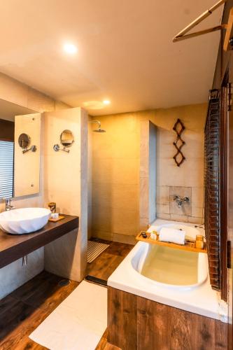 a bathroom with a large tub and a sink at Polo Cherrapunjee Resort in Cherrapunji