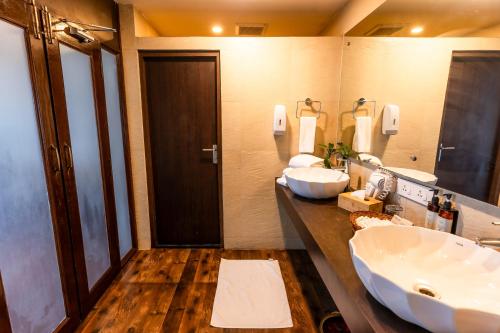 a bathroom with two sinks and a large mirror at Polo Cherrapunjee Resort in Cherrapunji