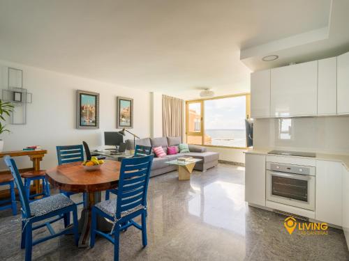 Una cocina y una sala de estar con mesa y sillas. en Living Las Canteras Homes - Seaview, en Las Palmas de Gran Canaria