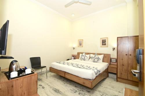 a bedroom with a bed and a desk and a television at Hotel Yulia in Jaipur