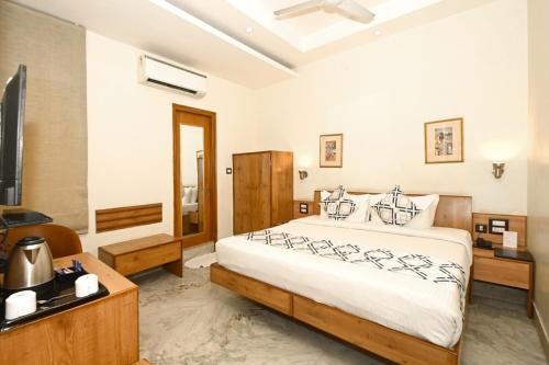 a bedroom with a large bed and a television at Hotel Yulia in Jaipur