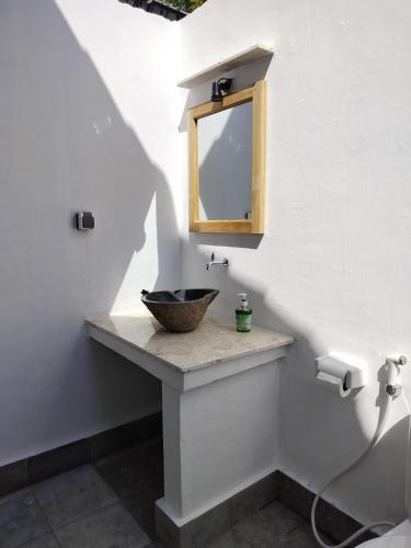 a bathroom with a bowl sink and a mirror at MASYA Cottages in Gili Trawangan