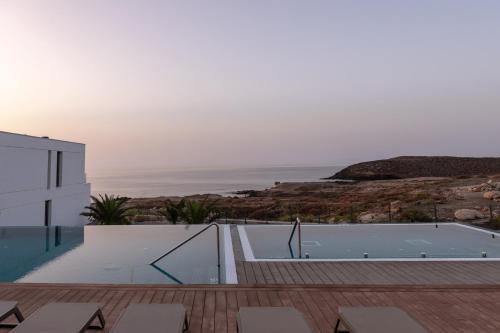 a house with a swimming pool and a view of the ocean at Kora Nivaria Beach in Abades