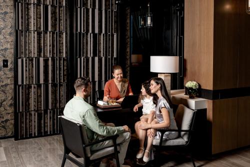 a group of people sitting around a table in a room at Banyan Tree Dubai at Bluewaters in Dubai