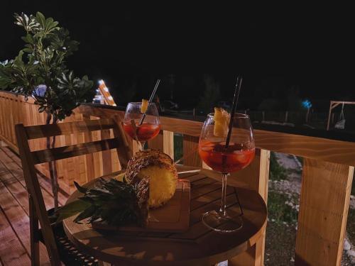 a table with two glasses of wine on a deck at Thethi Villas in Theth