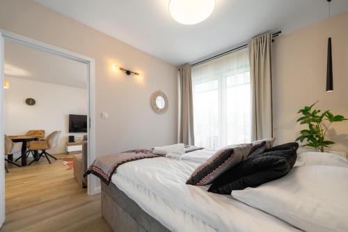 a bedroom with a large bed and a large window at RentPlanet - Apartamenty Zakopiańskie in Zakopane