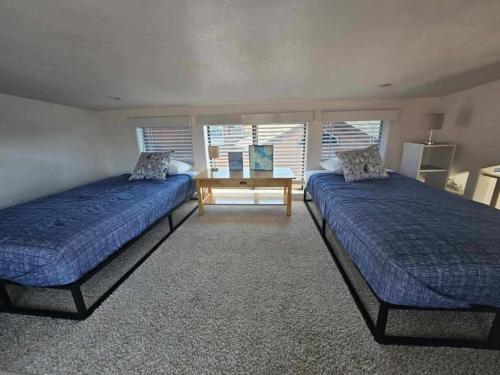 a bedroom with two beds and a table in it at Sand Castle - Ocean Cabin 25 W Private Jacuzzi in Smith River