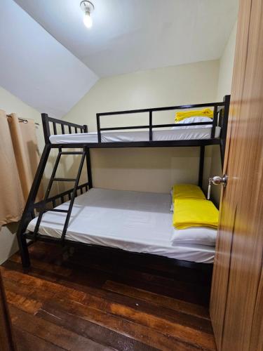 a bedroom with two bunk beds with yellow pillows at The Catolico's 2 bedroom Transient in Baguio