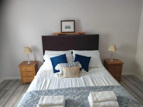 a bedroom with a large bed with blue pillows at The Beach House Annalong Cosy beachview cottage in Annalong