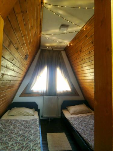 two beds in a small room with a window at Bunloc House in Braşov