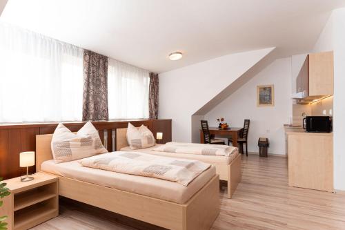 a bedroom with two beds and a table in it at SISI Pension in Púchov