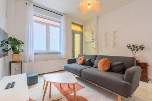 ein Wohnzimmer mit Sofa und Tisch in der Unterkunft Maison 3 chambres rénovée, proche centre-ville in Marcq-en-Baroeul