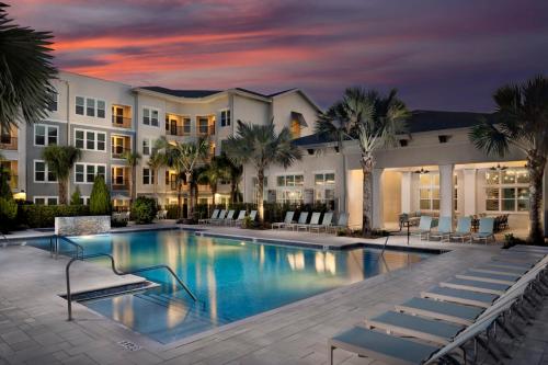 a pool at a resort with palm trees at Gated Resort Style 2BR - KING Bed, Pool Views, SPA Hot Tub, Gym, WiFi, Wash & Dry, AC, Elevators, Starbucks, EV CHRG Station, Free Parking, Pets -- IDEAL FOR Medical, Business, Relocation, Long Stays - by Moffitt Cancer Ctr, USF, River Hills Country Club in Tampa