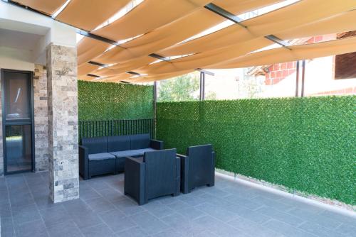 a patio with a green wall with a blue couch at Apartmani Putnik in Vrnjačka Banja