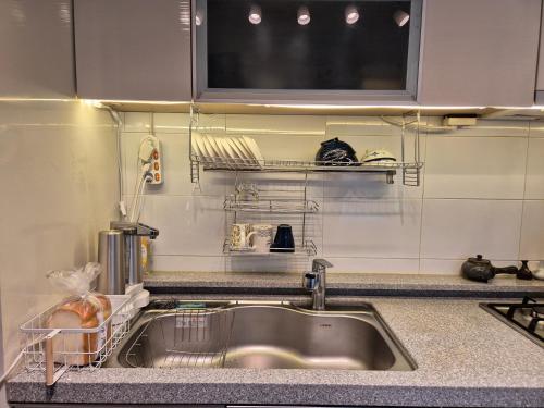 a kitchen counter with a sink and a microwave at MIN Stay - Woman Only Homestay in Seoul