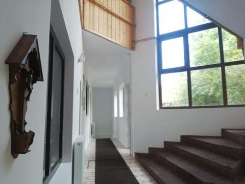 a hallway with stairs and a large window at Egyszerű és nagyszerű Hostel in Gheorgheni
