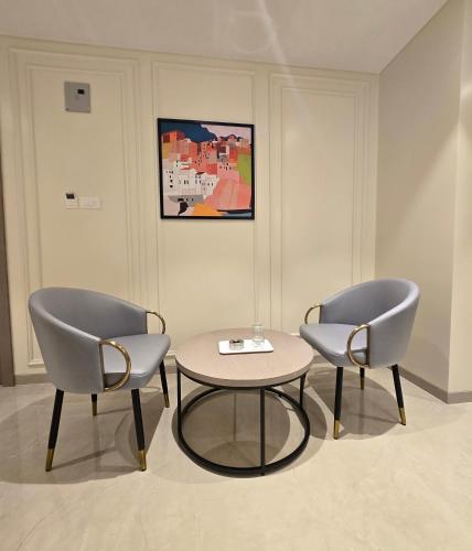 two chairs and a table in a room at Western Hotel in Chandrapur