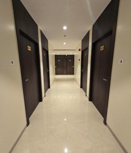 a hallway of a building with dark wood doors at Western Hotel in Chandrapur
