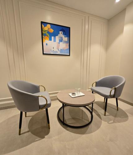 a room with two chairs and a table and a painting at Western Hotel in Chandrapur