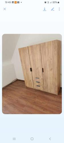 a wooden cupboard in the corner of a room at Egyszerű és nagyszerű Hostel in Gheorgheni