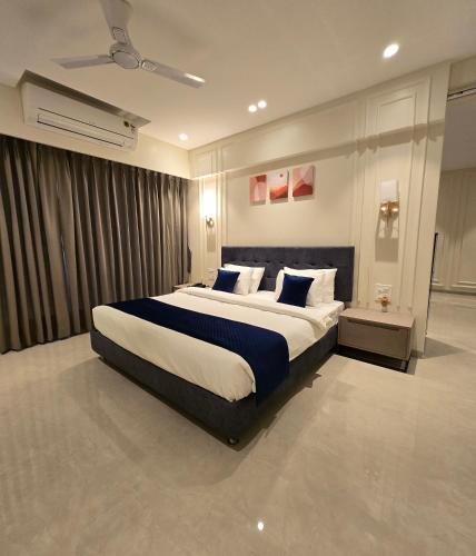 a bedroom with a large bed with blue and white pillows at Western Hotel in Chandrapur