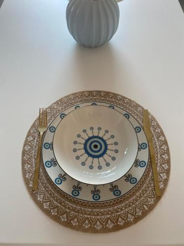 a plate sitting on a table next to a vase at Blue Eye in Amfilochía