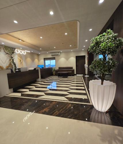 a lobby with a waiting area with a plant at Western Hotel in Chandrapur