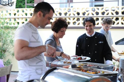 a man serving a woman a plate of food at Hotel Minaret&Étterem in Eger