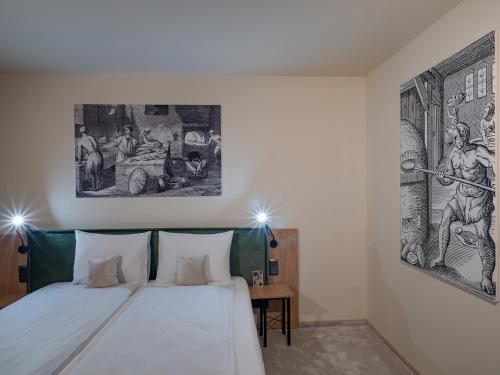 a bedroom with a bed with two pictures on the wall at Craft Inn - Boutique Hotel in Sibiu