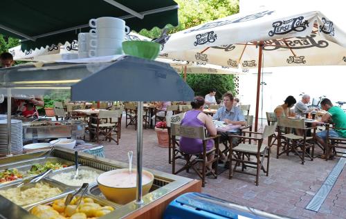 a food cart with people sitting at tables under umbrellas at Hotel Minaret&Étterem in Eger