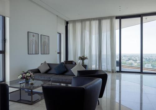 a living room with a couch and chairs and a table at Nicosia Central Park Residences in Nicosia