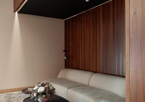 a living room with a white couch and a wooden wall at Nicosia Central Park Residences in Nicosia