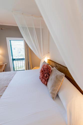 a bedroom with a large white bed and a window at Hotel Tarongeta - Adults Only in Cadaqués