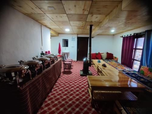 una stanza con tavoli e sedie e una stanza con divano di Peace Homestay Ladakh by LexStays a Leh
