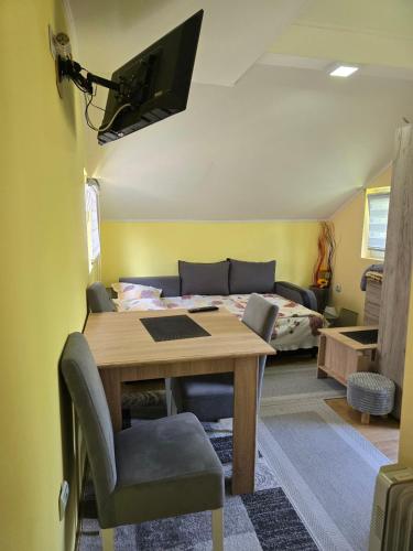 a living room with a table and a bed at Srebrna dolina in Kremna