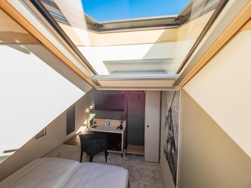 an attic bedroom with a skylight and a desk at Craft Inn - Boutique Hotel in Sibiu