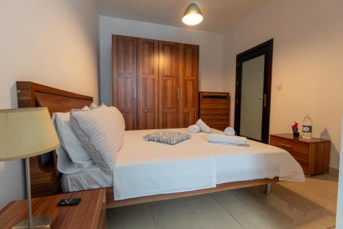 a bedroom with a large white bed and a lamp at Cozy Bedroom, shared bathroom -Gzira in Il-Gżira