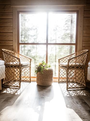 two chairs in a room with a large window at Forest Cabin Ainola next to Nuuksio National Park, in addition Hot Tub and Breakfast in Otalampi