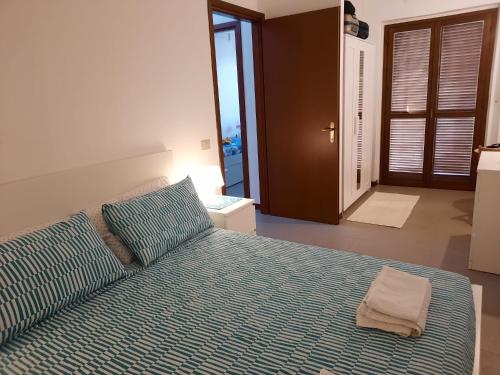 a bedroom with a bed with a blue comforter at Casa Luca ai Borghi di Villasimius in Villasimius